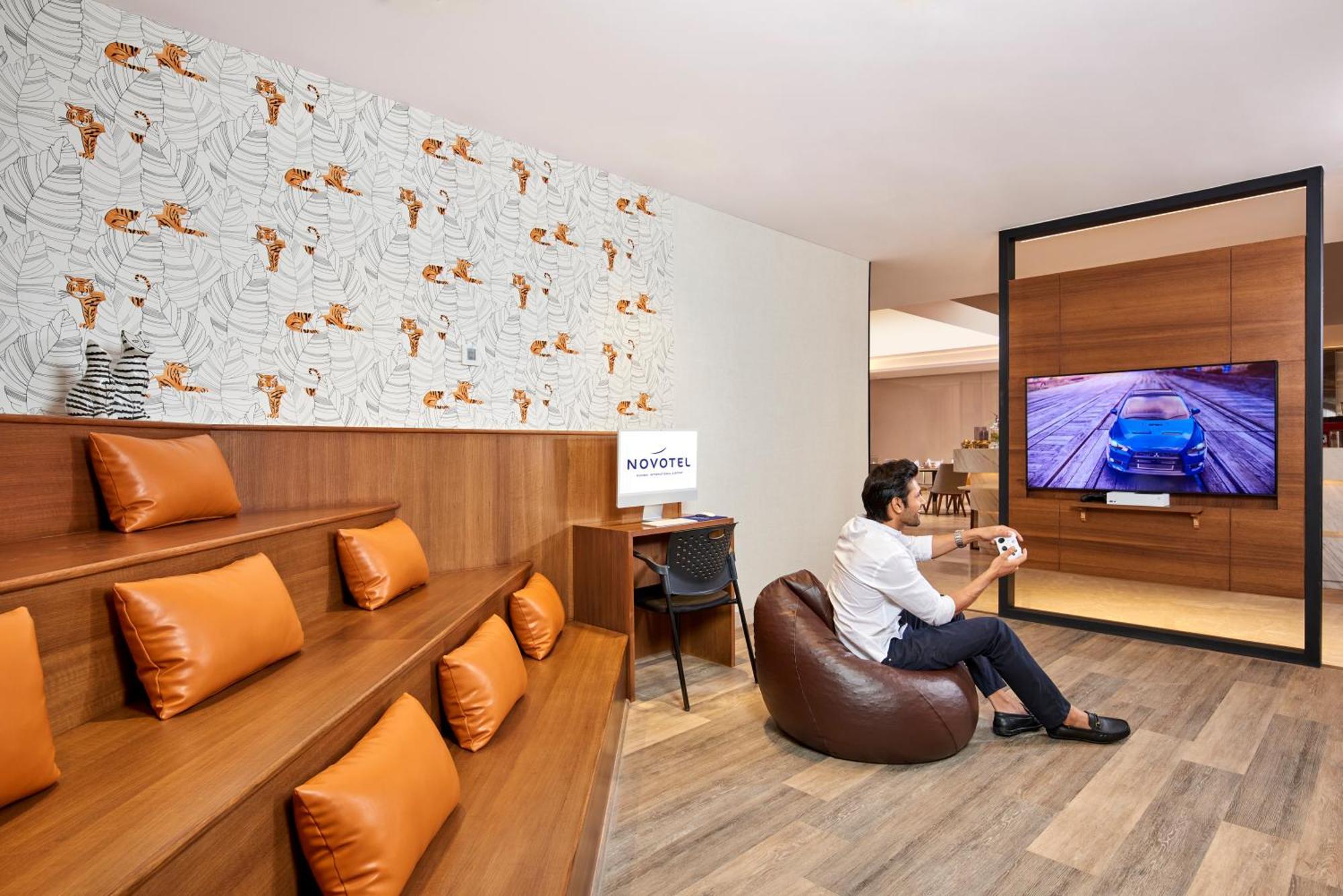 Novotel Mumbai International Airport Εξωτερικό φωτογραφία A man playing a video game at the lounge